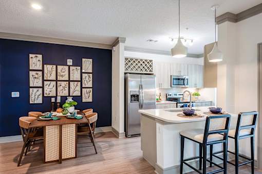 A kitchen with a dining table and chairs.