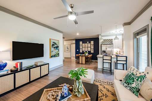 A living room with a flat screen TV, a sofa, and a coffee table.