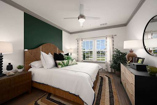 A bedroom with a large bed and a ceiling fan.