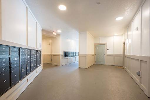A large, empty room with white walls and a grey floor.