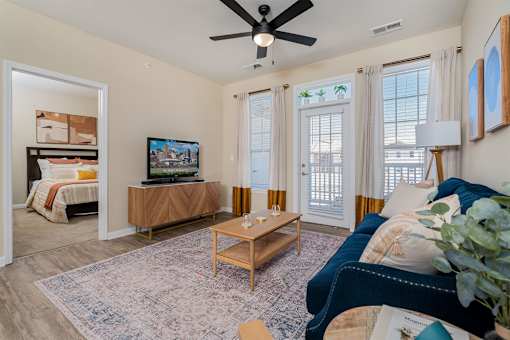 A living room with a ceiling fan and a television.