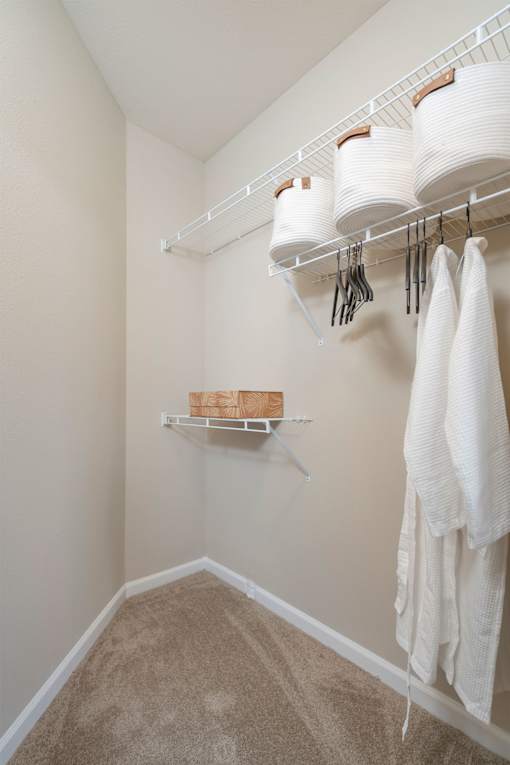 A white laundry room with a carpeted floor and a white towel hanging on the rack.