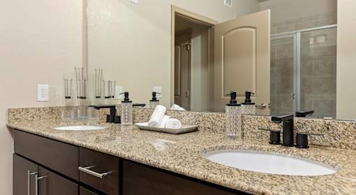 A bathroom with two sinks and a large mirror.