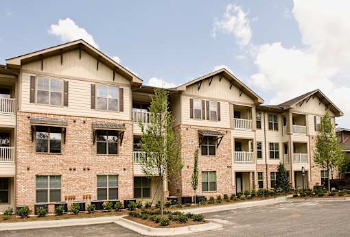 Apartment building with a parking lot in front.