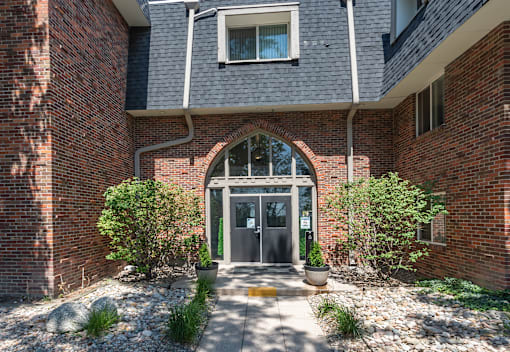 A brick building with a large arched entrance and a small window above it.