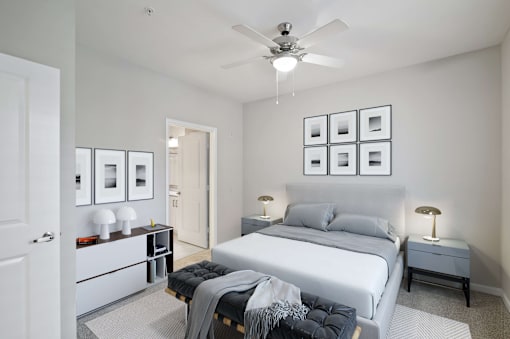 A bedroom with a bed, nightstands, and pictures on the wall.