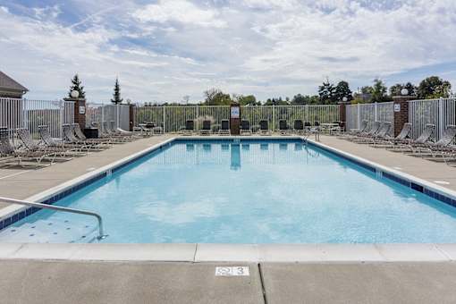 A large outdoor swimming pool surrounded by a metal fence.