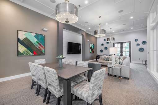 A modern dining room with a large table and chairs.