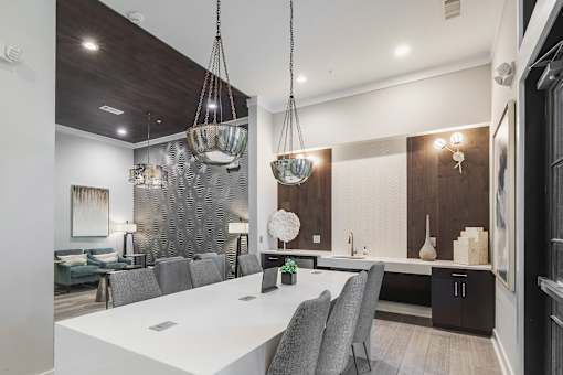 A modern dining room with a white table and grey chairs.