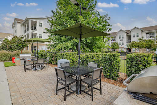 A patio with a table and chairs under an umbrella.