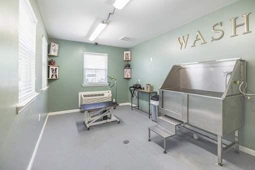 A room with a wash sign on the wall and a couple of sinks.