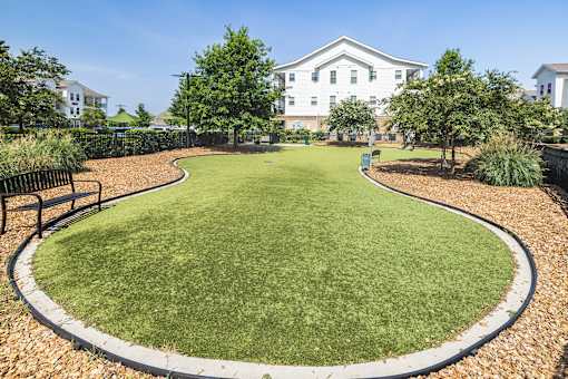 A grassy area with a white building in the background.