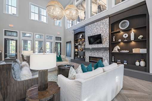 A modern living room with a white couch and a fireplace.