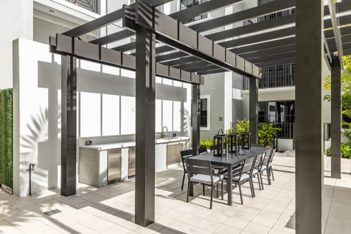 a patio with a table and chairs under a pergola at Leena Plantation, Plantation, FL