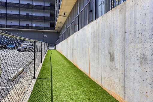 A long concrete wall with a green grassy area in the middle.