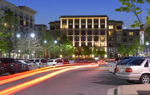 Cars are parked on the side of the road at night.
