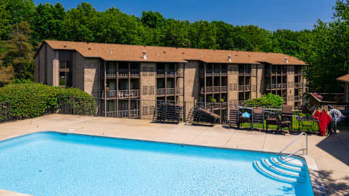 A swimming pool in front of a building with a person in a red shirt standing near the pool at Winchell Way Apartment , Kalamazoo, 49008