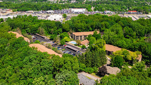 A large building surrounded by trees is seen from above at Winchell Way Apartment , Kalamazoo, 49008