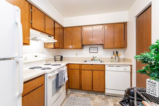 A kitchen with wooden cabinets and white appliances at Winchell Way Apartment , Kalamazoo, 49008