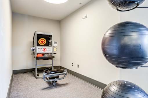 A room with a Pilates reformer and a large exercise ball.