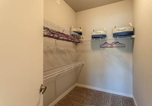 an empty closet with two shelves and two baskets on a rack
