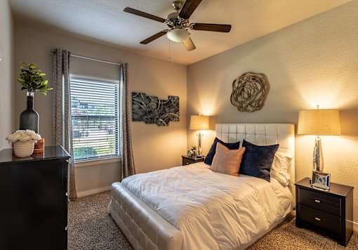 a bedroom with a large bed and a ceiling fan