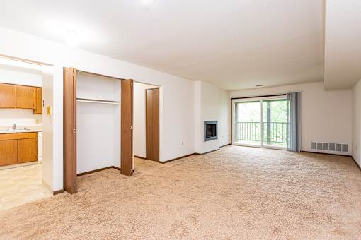 A large, empty room with a sliding glass door leading to a balcony at Winchell Way Apartment , Kalamazoo, 49008
