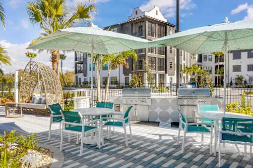 A patio with white furniture and green umbrellas.