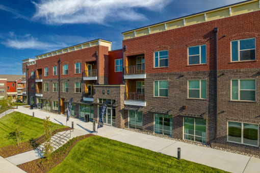 Mt. Juliet, TN Apartments for Rent - The Enclave at Providence - Street View of Property with Manicured Grass Lawn and Wide Concrete Walkway.