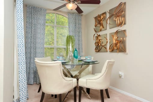 a dining room with a table and chairs and a window