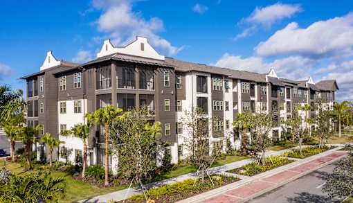 A large apartment complex with a red and white walkway in front.
