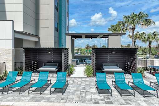 A row of blue lounge chairs are set up on a patio.