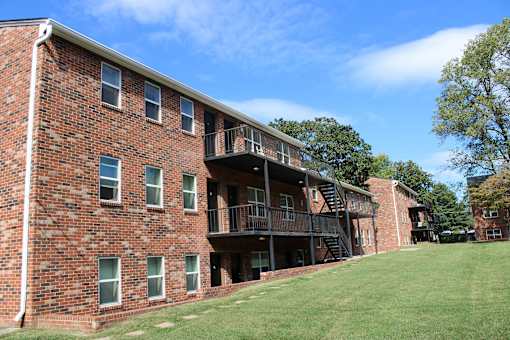 A red brick building with a balcony and stairs.