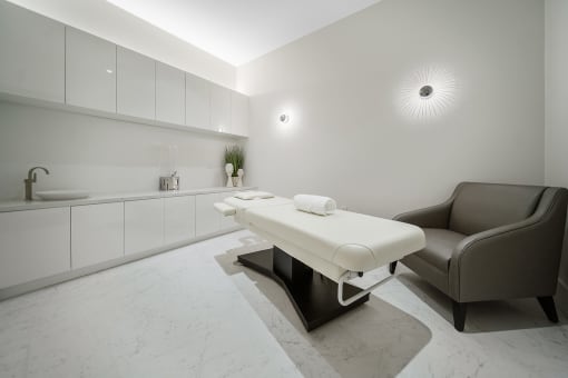 a spa room with a massage table and chair at Altis Grand Central, Florida, 33606