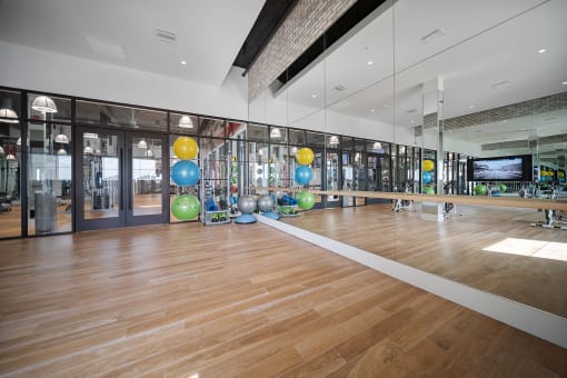 a large gym with a wooden floor and large mirrors on the wall at Altis Grand Central, Tampa, 33606