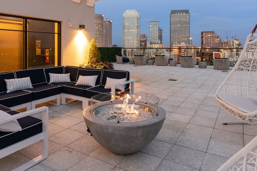 a fire pit on a roof terrace with a view of the dallas skyline at Altis Grand Central, Tampa, FL