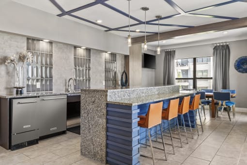 a kitchen and dining area in a hotel with blue chairs