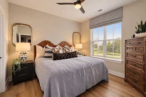 A bedroom with a bed, dresser, and mirror.