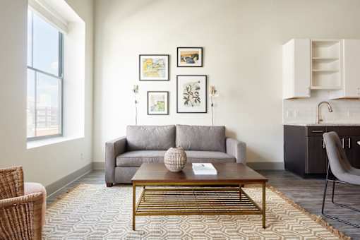 A living room with a grey couch, a coffee table, and a chair.