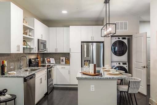 A modern kitchen with white cabinets and stainless steel appliances.