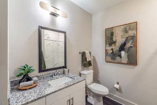 A bathroom with a mirror, toilet, and sink.