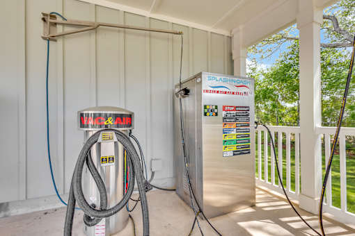 A gas pump and a Splashdown refrigerator are on a porch.