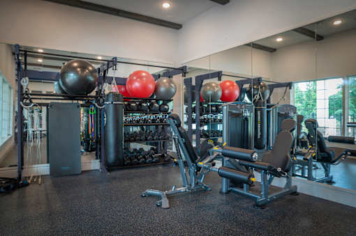 A gym with a variety of equipment including weights and machines.