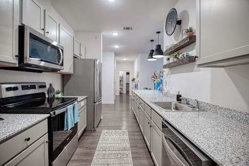 A modern kitchen with granite countertops and stainless steel appliances.