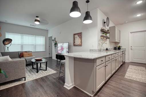 A modern kitchen with a large island and pendant lights.