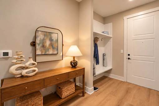 A hallway with a wooden bench and a lamp on it.