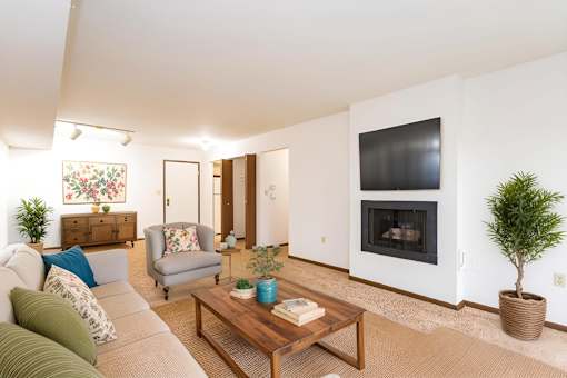 A living room with a grey couch, a coffee table, a fireplace, and a potted plant at Winchell Way Apartment , Kalamazoo, 49008