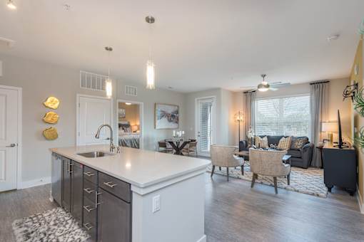 A modern kitchen with a large island and a dining area with a couch and chairs.