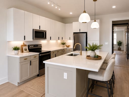 A modern kitchen with a white island and a black refrigerator.