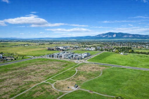 A large building complex is surrounded by a green field.